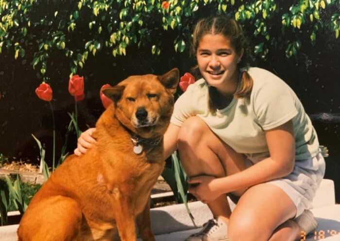 Golden Chow Mix sitting next to young girl