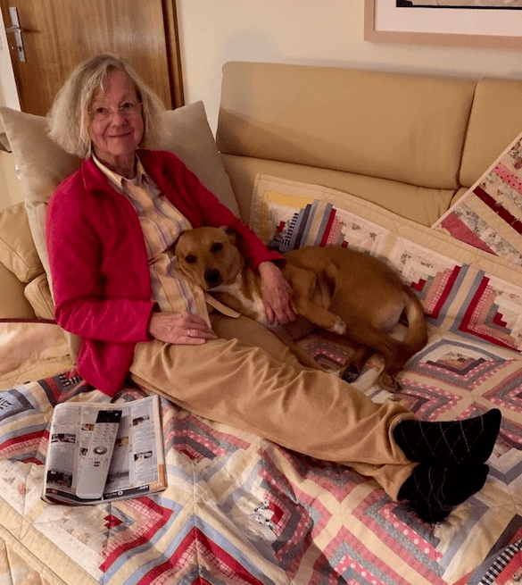 My mom cuddles with my dog Wally. His entire body is relaxed, including his tail, ears and eyes.